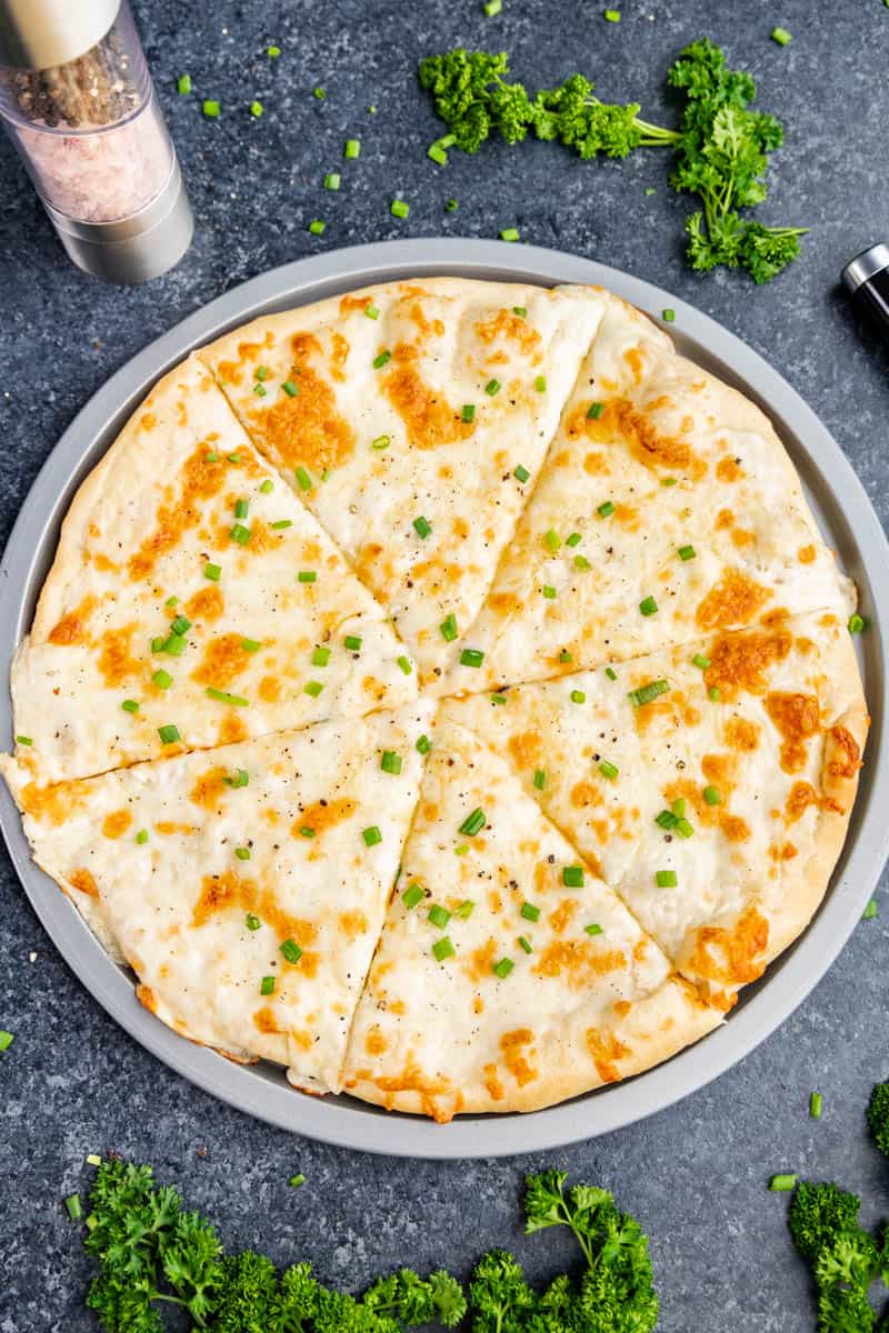 Overhead view of a whole creamy Alfredo pizza.