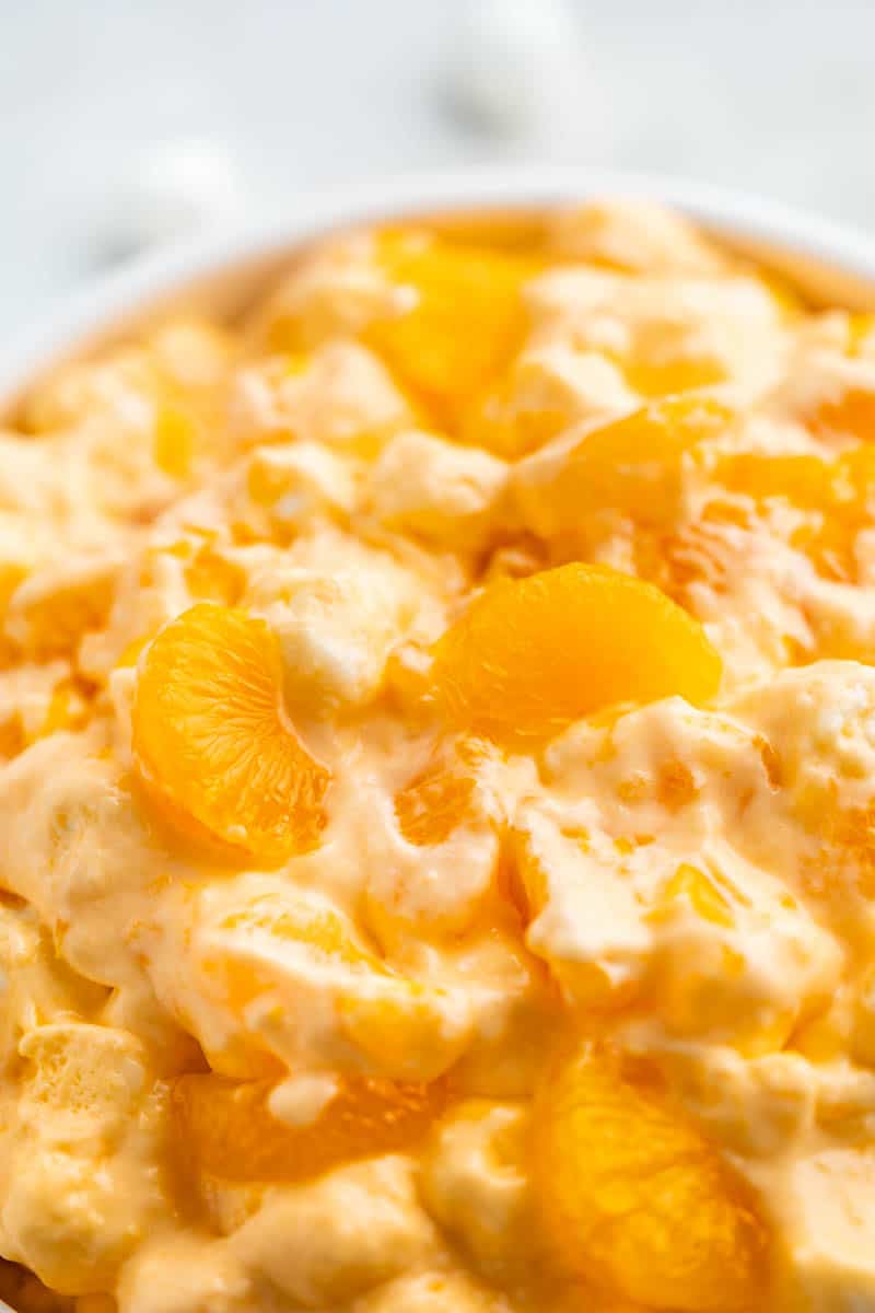 Close up view of orange creamsicle salad in a large bowl.