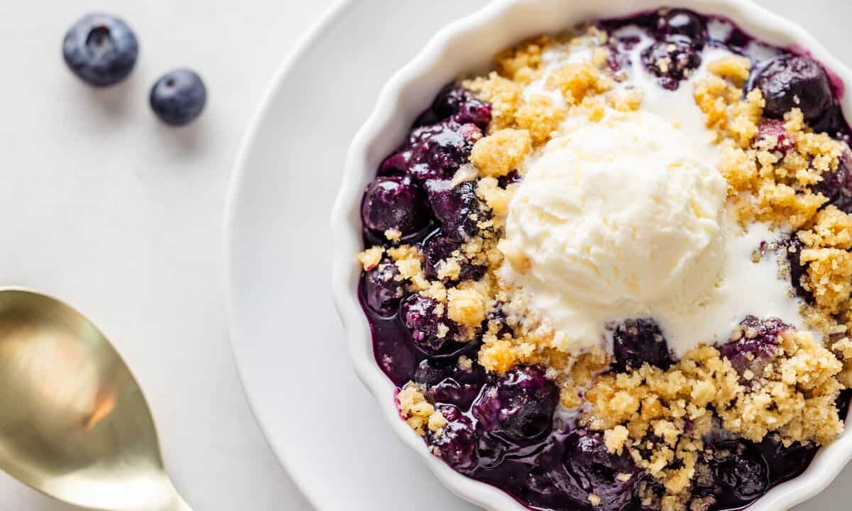 Overhead view of a blueberry crumble in a small dish.