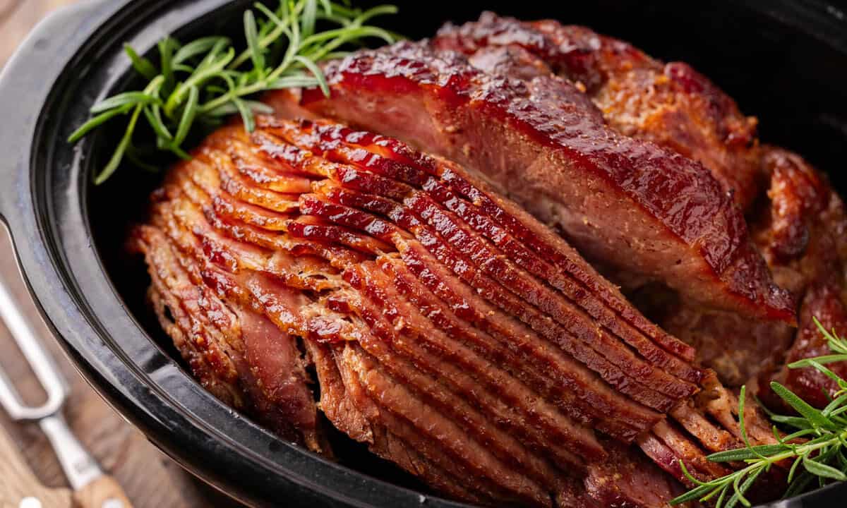 Close up view of a cooked spiral ham in a slow cooker.