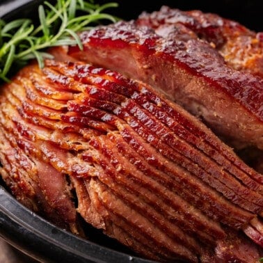 Close up view of a cooked spiral ham in a slow cooker.