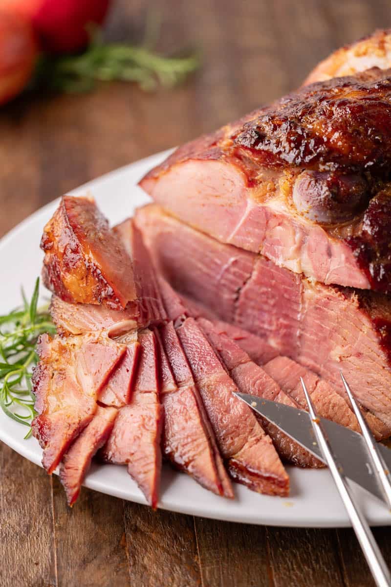 Sliced spiral ham on a white serving platter.