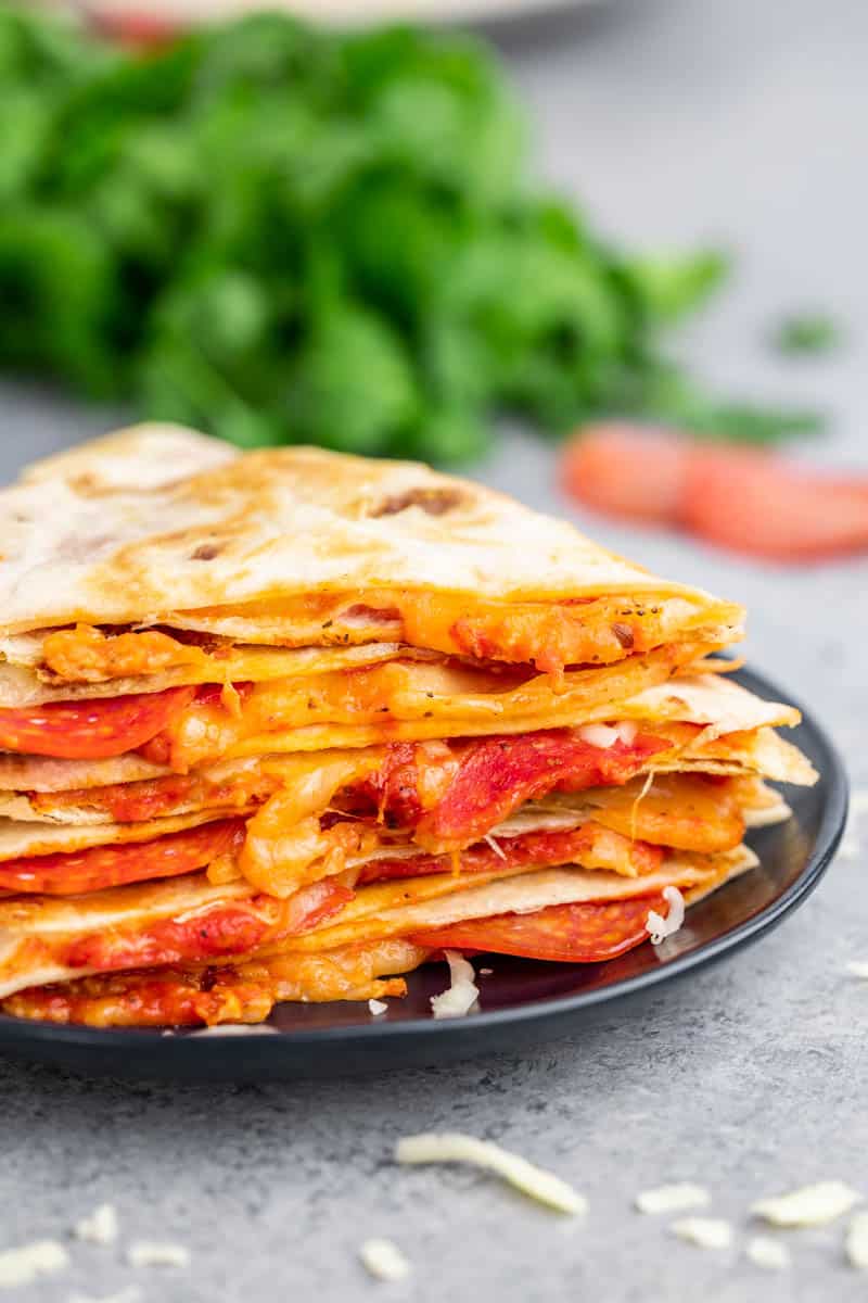 Close up view of a stack of pizza quesadillas.