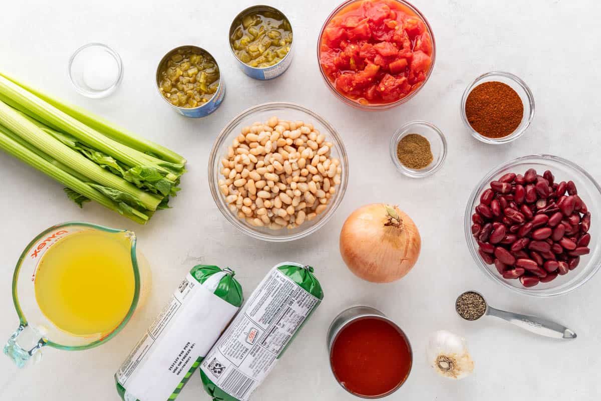 Overhead view of the raw ingredients needed to make turkey chili on a clean kitchen counter.