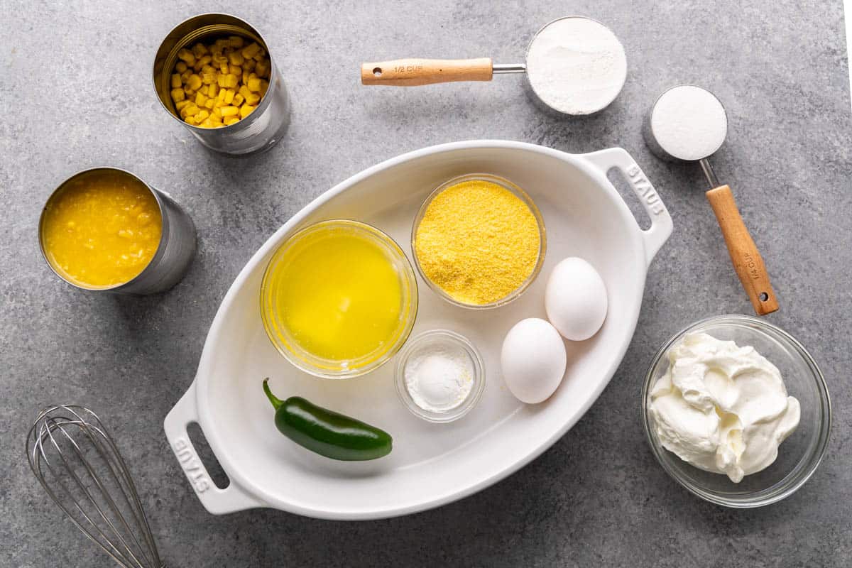 Overhead view of the raw ingredients needed to make corn casserole, on a clean kitchen counter