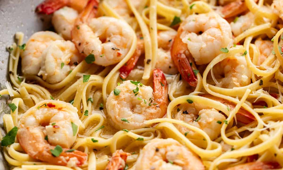 Close up view of shrimp scampi in a large skillet.