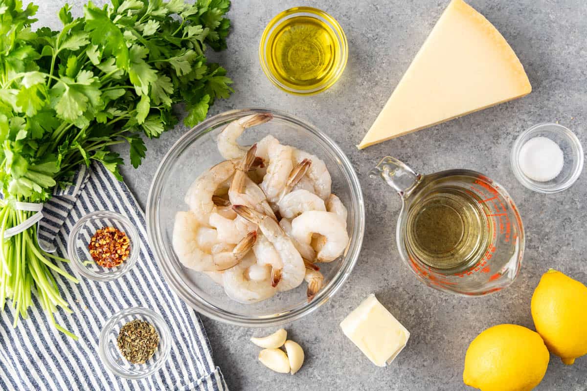 Overhead view of the raw ingredients needed to make shrimp scampi on a kitchen counter.