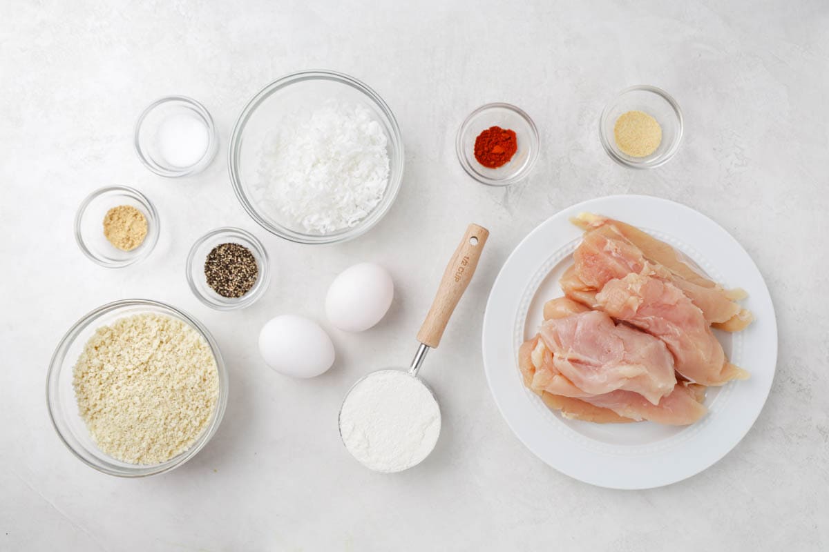 An overhead view of the raw ingredients needed to make crispy coconut chicken.