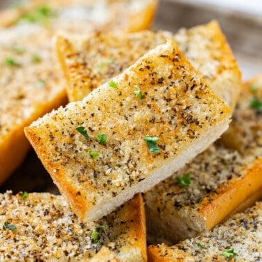 Garlic bread that has been cut into pieces and piled on top of each other.