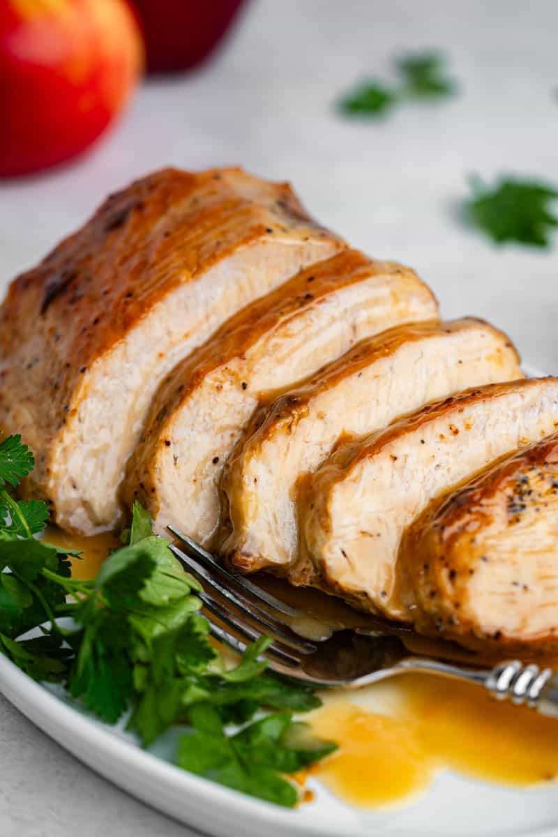 A glazed and sliced pork loin on a serving platter.