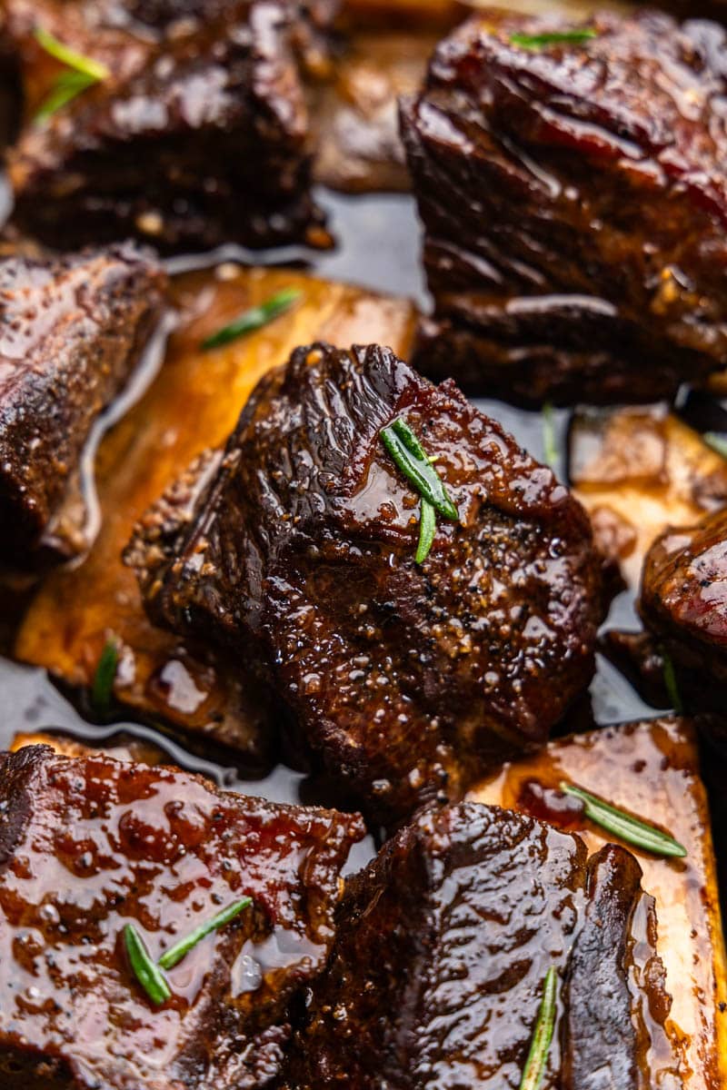 A close up view of braised beef short ribs in braising juices.