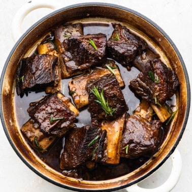 An overhead view of beef short ribs in a braising pan.