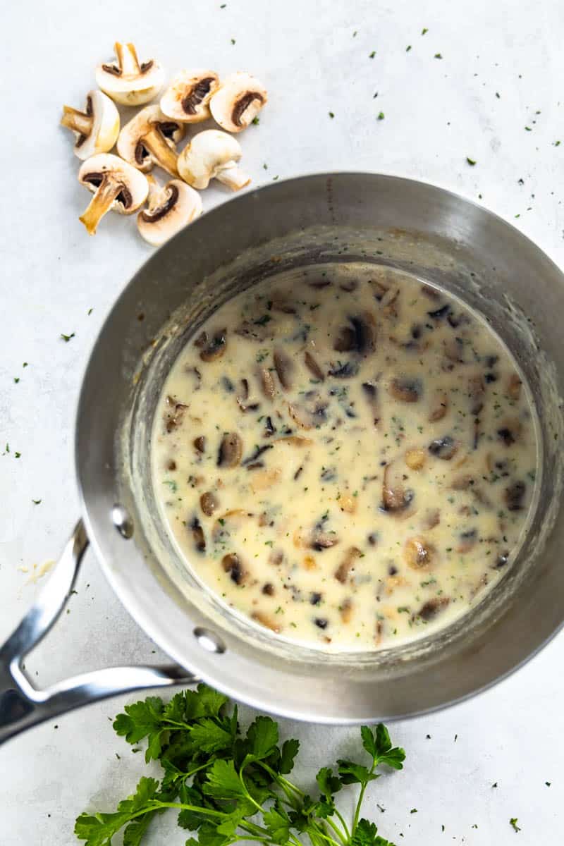 An overhead view of a saucepan filled with freshly made cream of mushroom soup.
