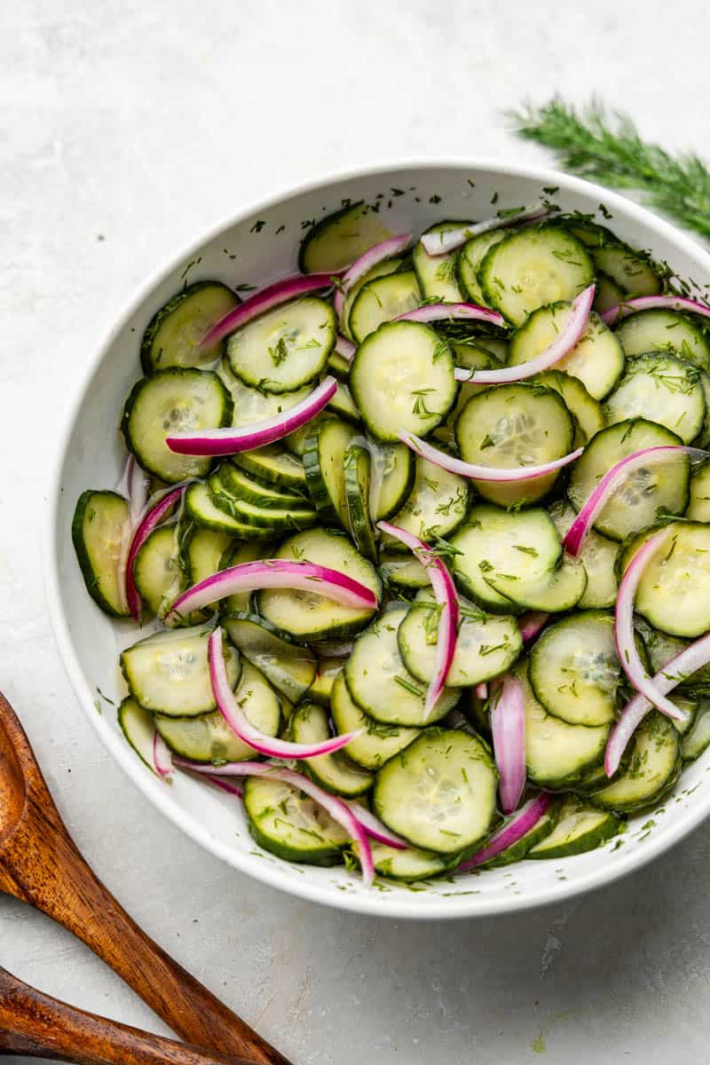 An overhead birds-eye view of a bowl of a vinegar-based cucumber salad.
