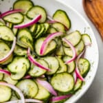 A close up view of a bowl of German-style cucumber salad.