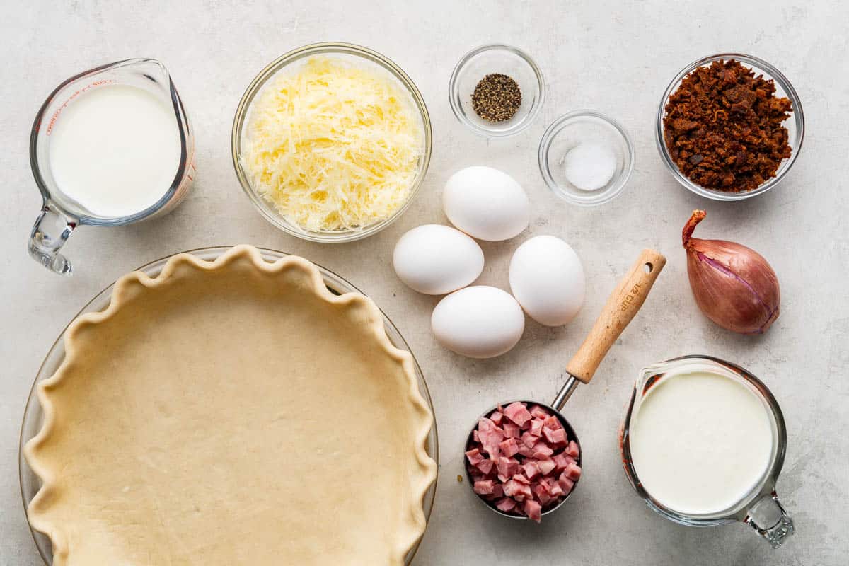 An overhead birds-eye view of the ingredients needed to make a classic basic quiche.