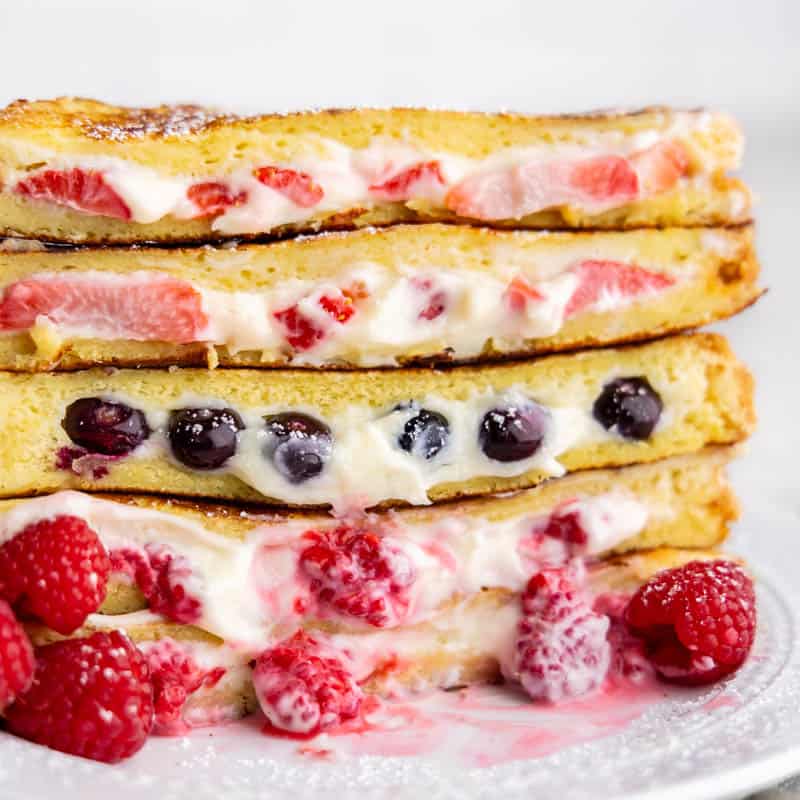 Stuffed French toast stacked on top of each other with berries inside.
