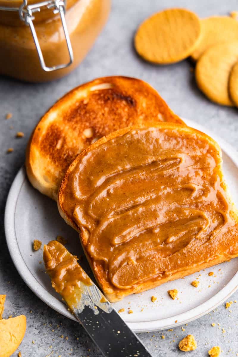 An overhead view of two pieces of toast on a plate slathered with homemade cookie butter. 