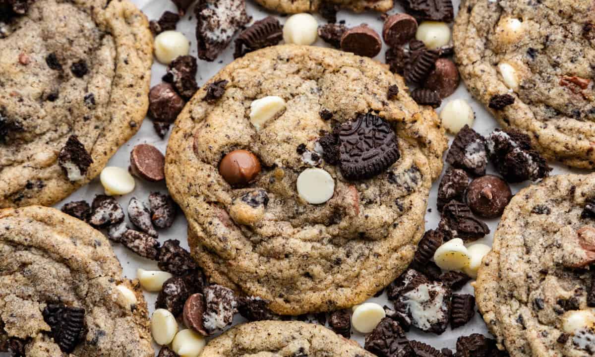 A close up view of cookies and cream cookies surrounded by cookie bits and chocolate chips.