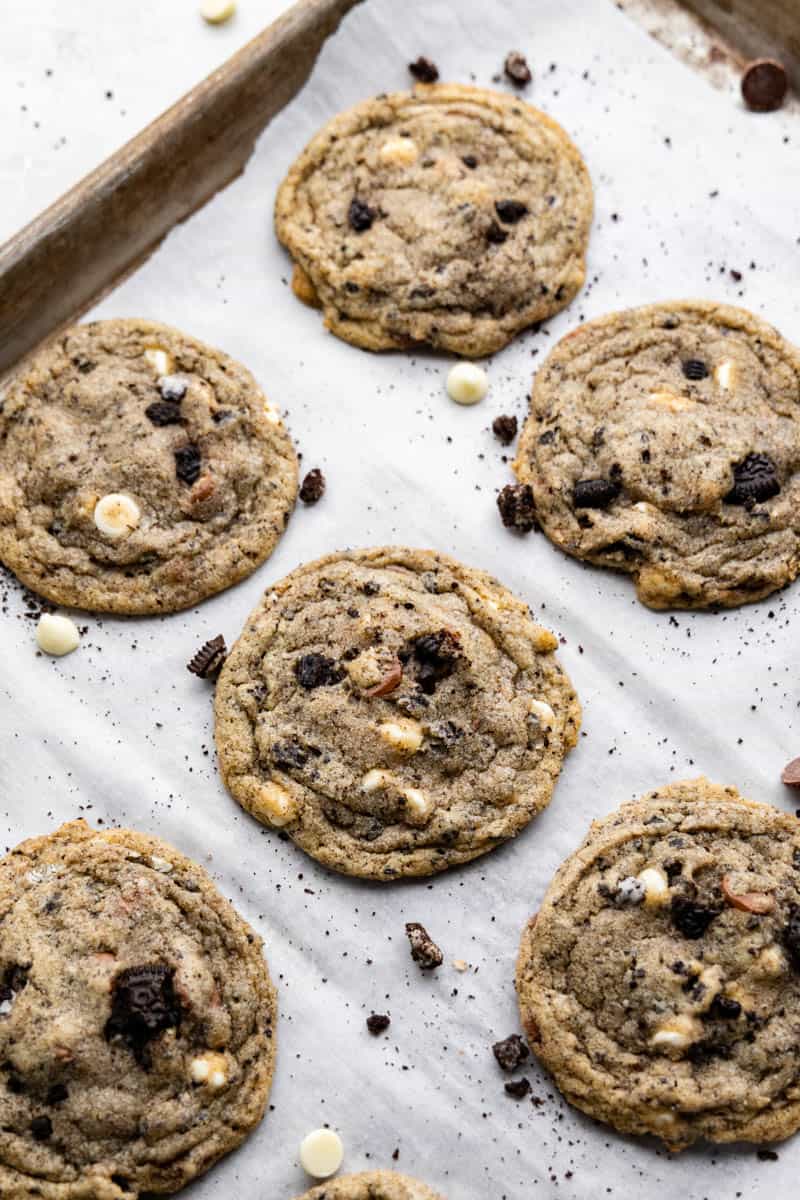 An overhead view of cookies and cream cookies on a parchment lined baking sheet.