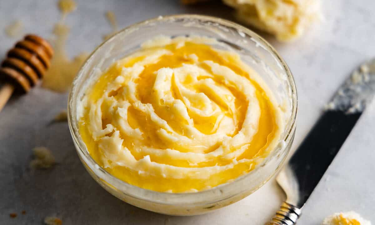 A close up view of a glass bowl filled with honey butter.