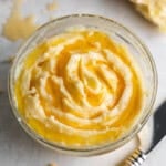 A close up view of a small glass bowl full of homemade honey butter.