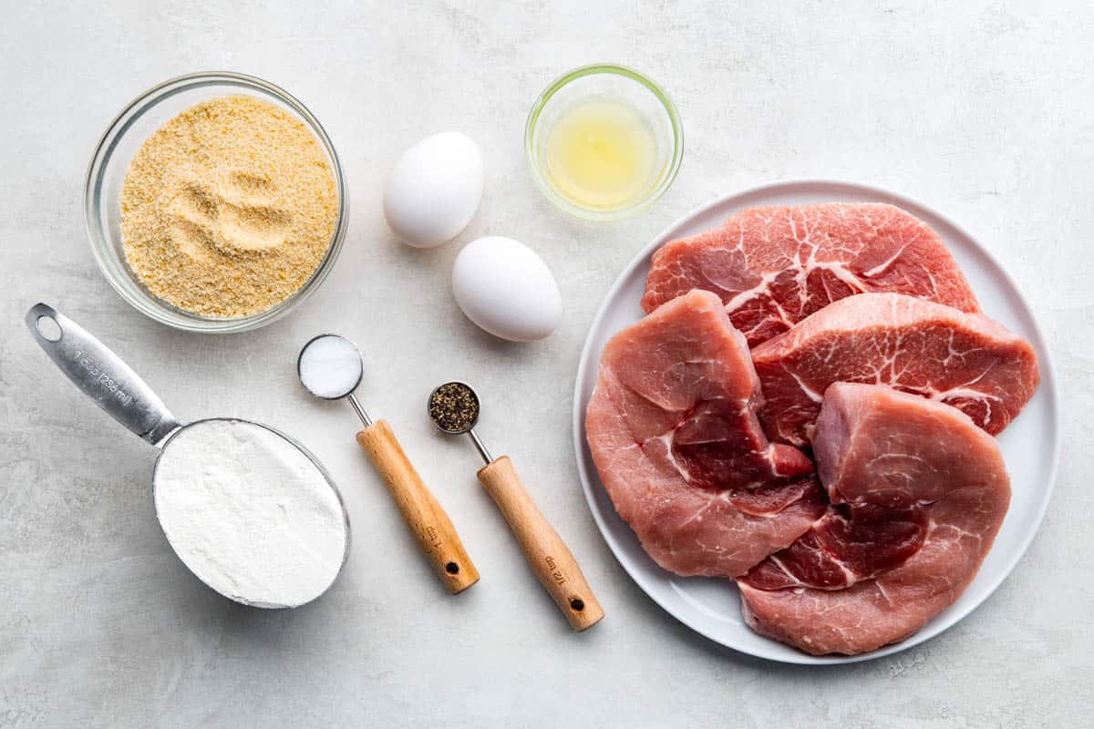 An overhead view of the ingredients needed to make pork schnitzel.