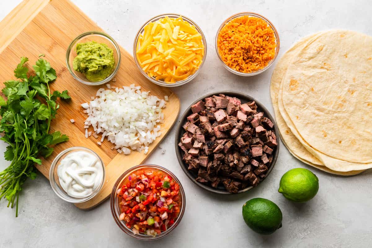 An overhead view of the ingredients needed to make a carne asada burrito.