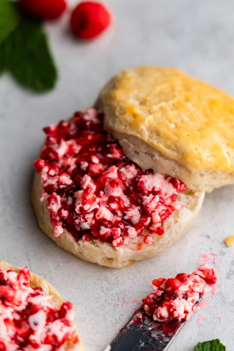 Raspberry butter that has been spread on a split biscuit.