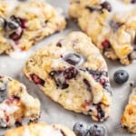 A close up view of homemade blueberry scones on a marble surface.