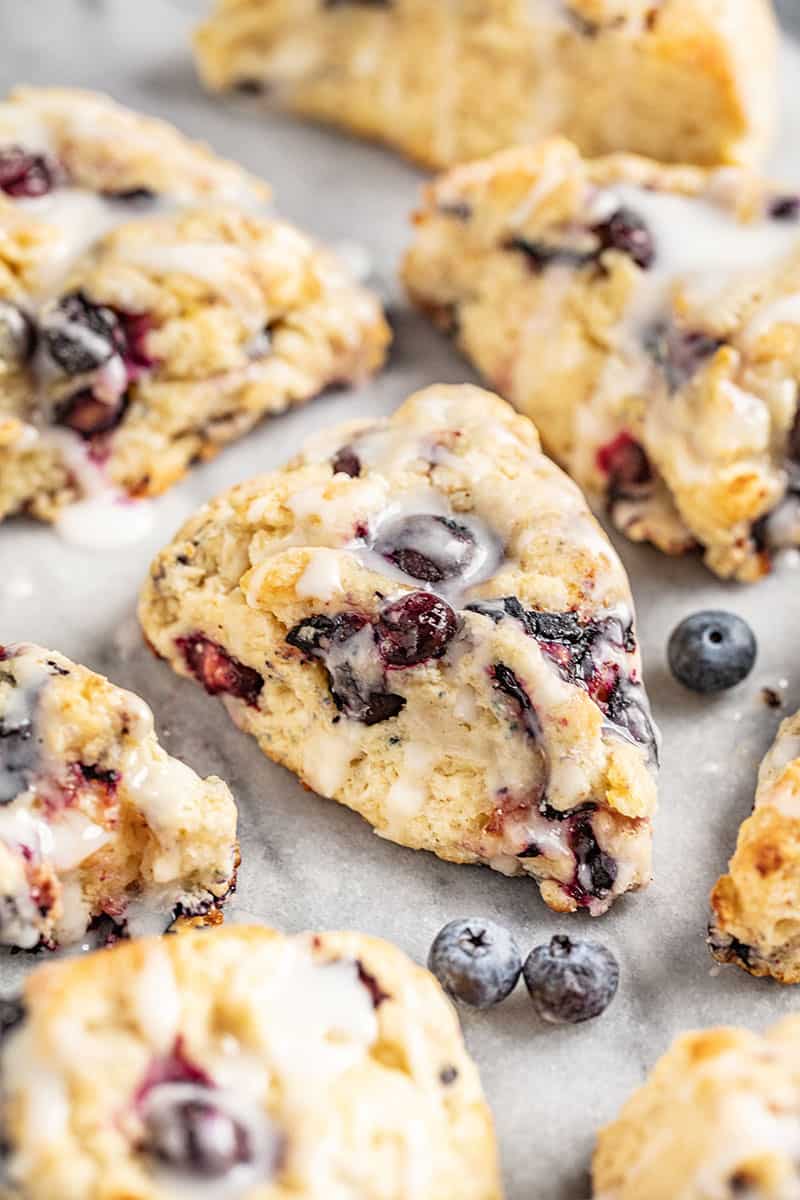 A close up view of homemade blueberry scones on a marble surface. 