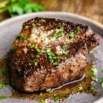 A close up view of a filet mignon steak on a plate.