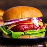 A close up view of a smoked burger on a black plate.