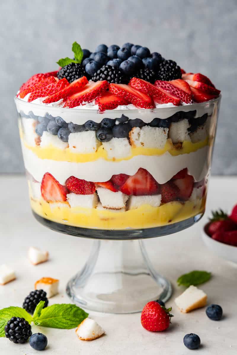 Side view of creamy berry trifle showing layers of fruit and cream.