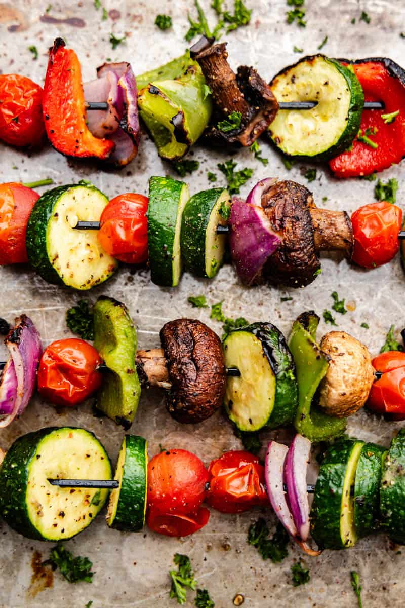 Close view of cooked grilled vegetable skewers laid out side by side.