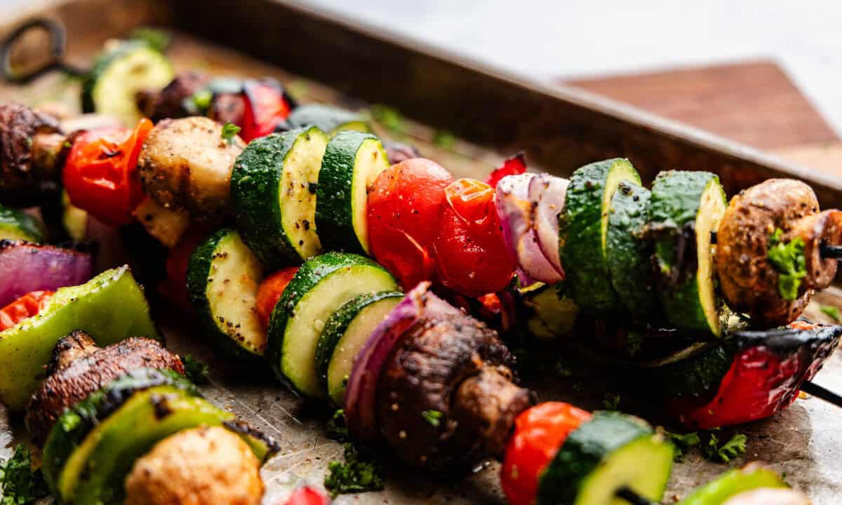 A close up view of skewers of vegetables for grilling.