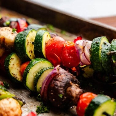 A close up view of skewers of vegetables for grilling.