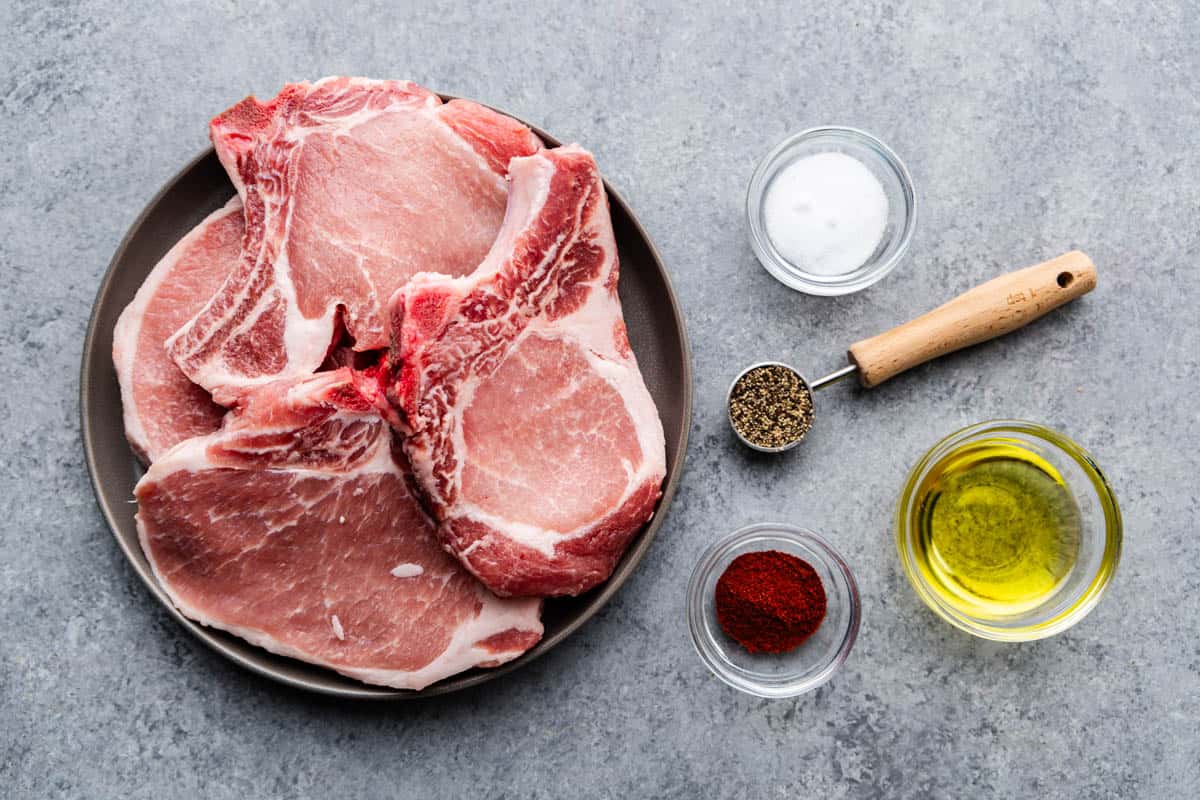 The ingredients for grilled pork chops laid out on a table.