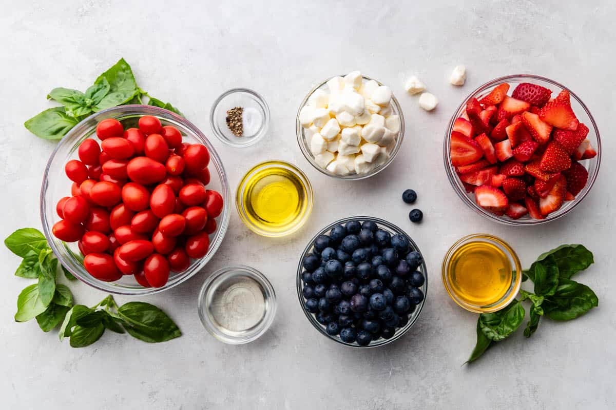 View of red, white and blue caprese salad ingredients on a table.