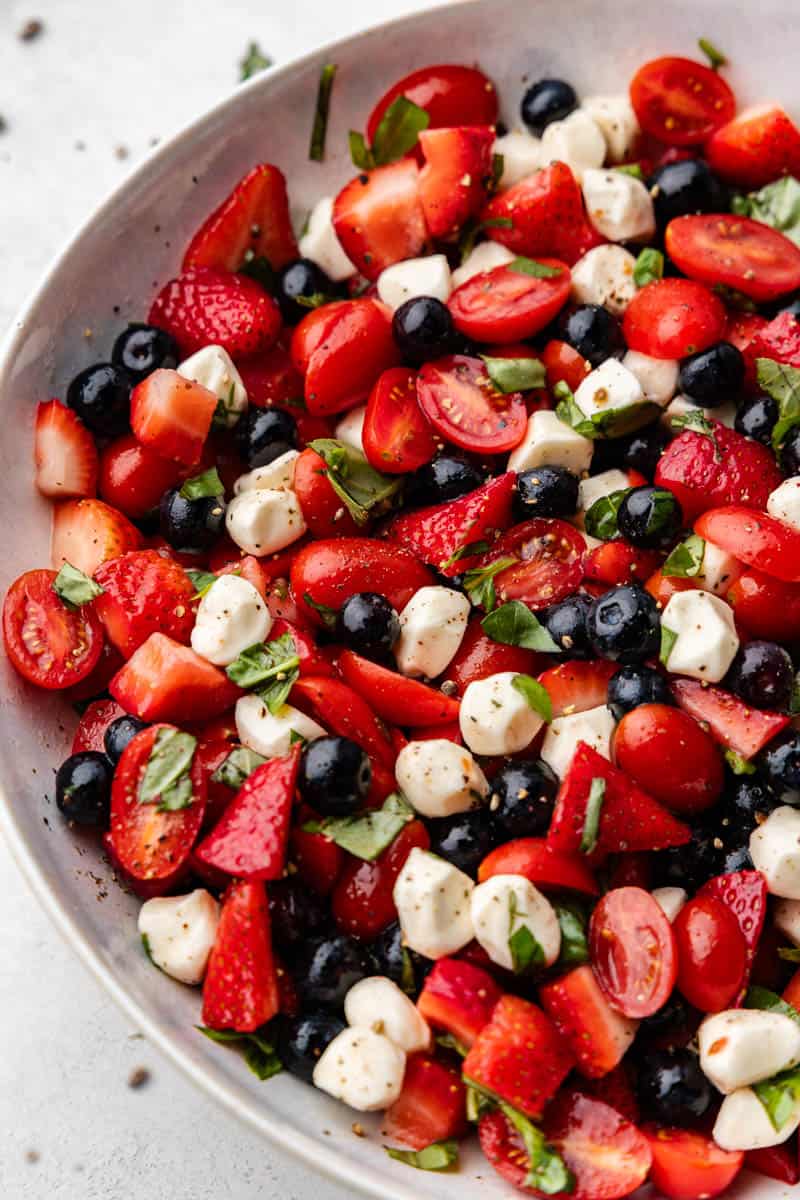 Large bowl of red, white and blue caprese salad.
