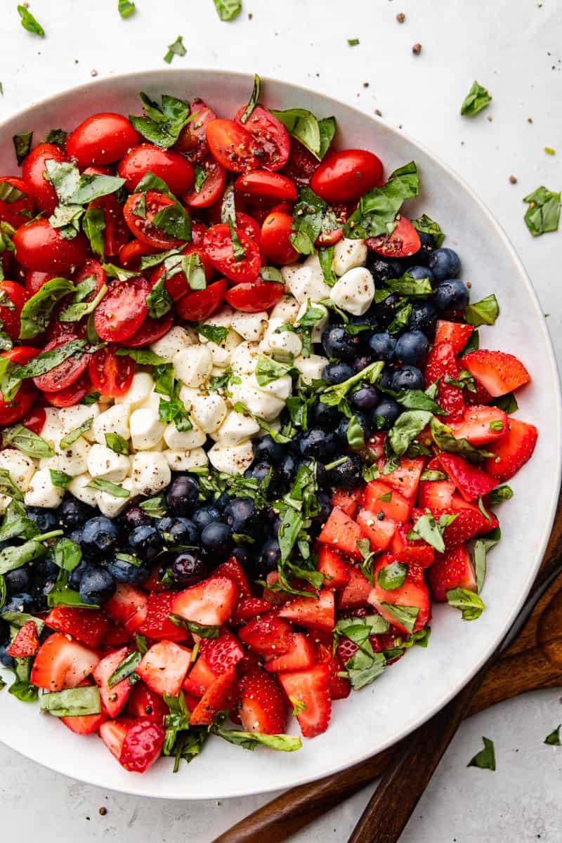 View of a red, white, and blue caprese salad with the colors of the ingredients arranged in stripes.