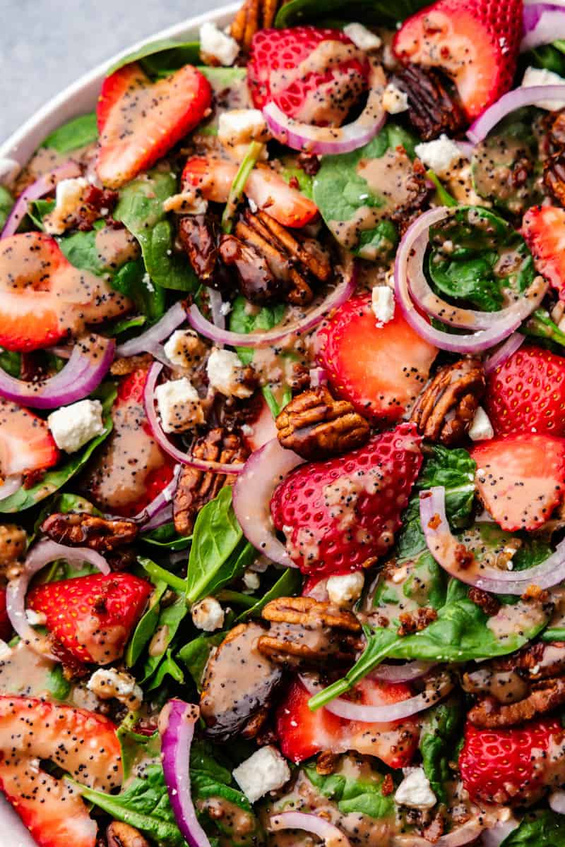 Close up view of a plate of spinach and strawberry salad.