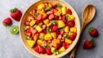 An overhead view of a bowl of summer fruit salad.