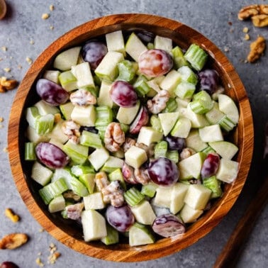 A view of Waldorf salad in a wooden bowl on a table.