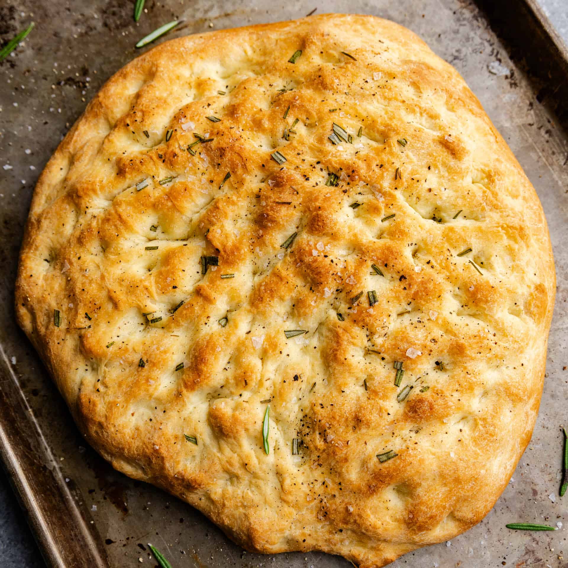 An overhead view of a loaf of homemade rosemary focaccia.