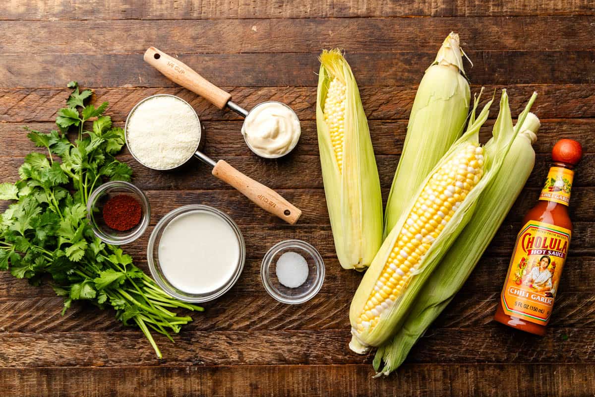 Ingredients for Mexican Street Corn are laid out on a wooden board.