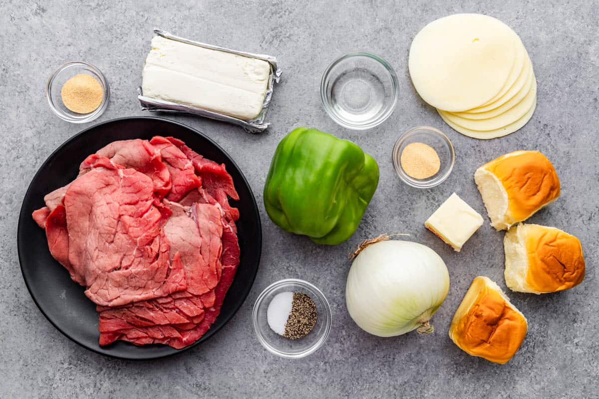 An overhead view of the ingredients needed to make Philly cheesesteak sliders.