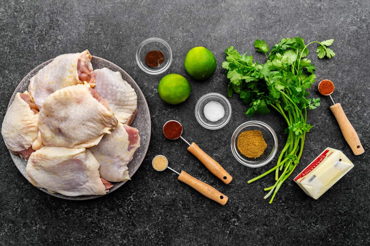 An overhead view of the ingredients needed to make mexican-spiced chicken thighs,