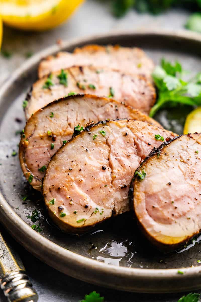 Delicious slices of pork tenderloin on a plate with vegetables. 