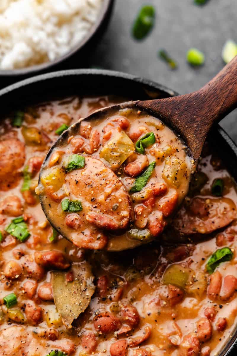 Serving red beans and sausage from a wooden spoon pot.